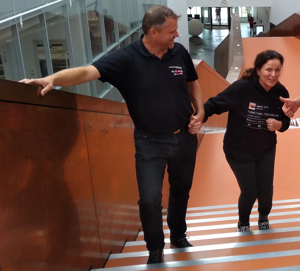 Tina walking up a staircase holding the handrail